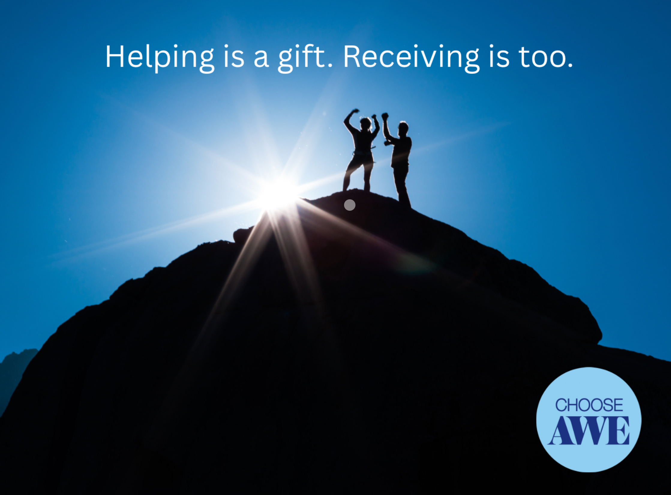 Silhouette of two people on a mountaintop reaching toward each other with sunlight streaming behind them, symbolizing connection and support. Overlay text reads: “Helping is a gift. Receiving is too.”